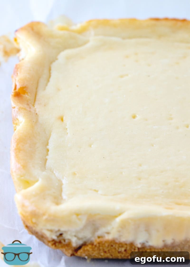 A fully baked square cheesecake, golden on the edges and perfectly set, cooling after coming out of the oven.