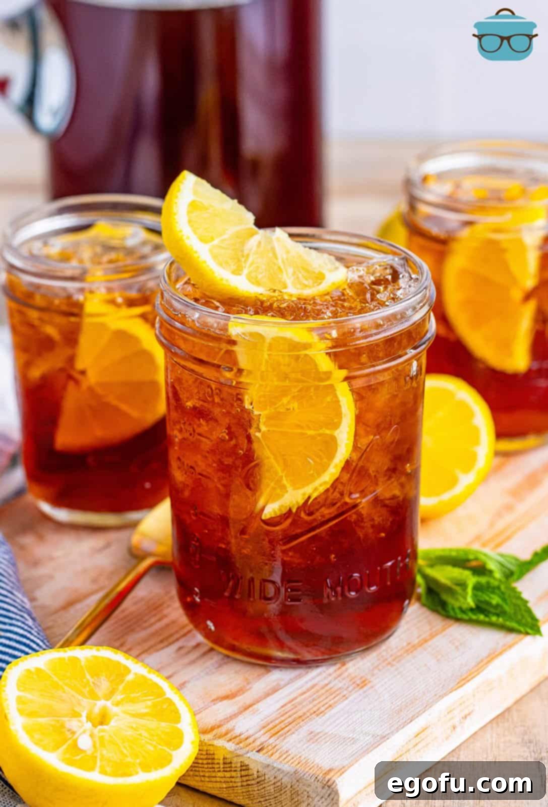 Three small mason jars of Southern Sweet Tea with lemon slices in them, radiating a refreshing appeal.