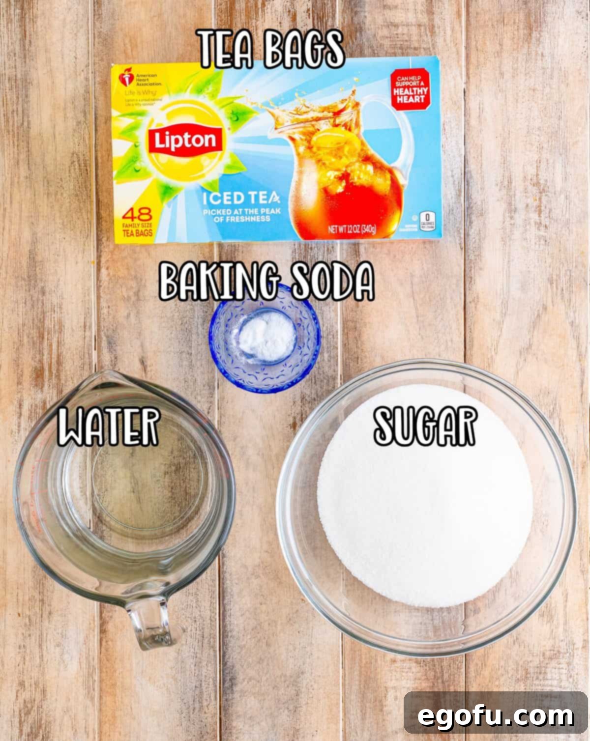A clear image displaying the essential ingredients: a box of Lipton tea bags, a container of baking soda, a pitcher of water, and a bowl of granulated sugar, ready for tea preparation.