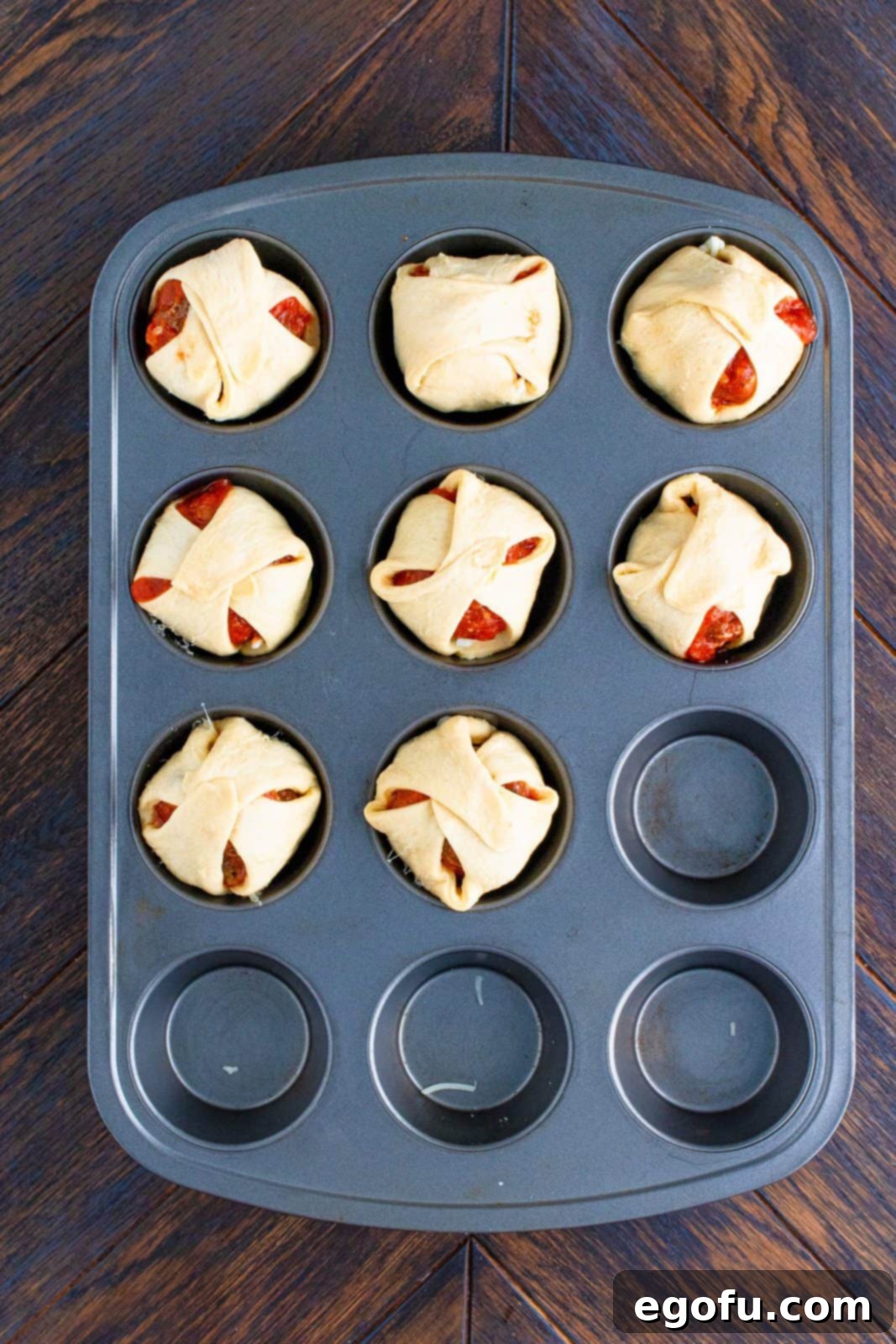 Crescent dough sheets folded over tops of meatballs.