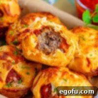 Square image of Meatball Sub Cups stacked with bite taken out of top one.