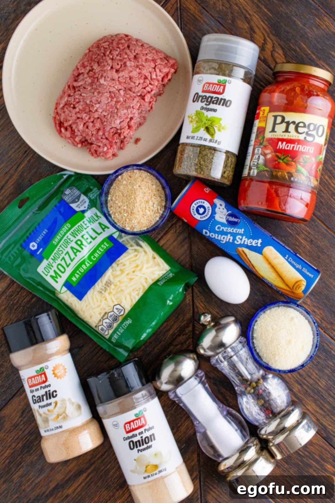 Ingredients needed: egg, parmesan cheese, plain breadcrumbs, garlic powder, onion powder, dried oregano, kosher salt, pepper, lean ground beef, crescent roll dough sheet, mozzarella cheese, marinara sauce and parsley.