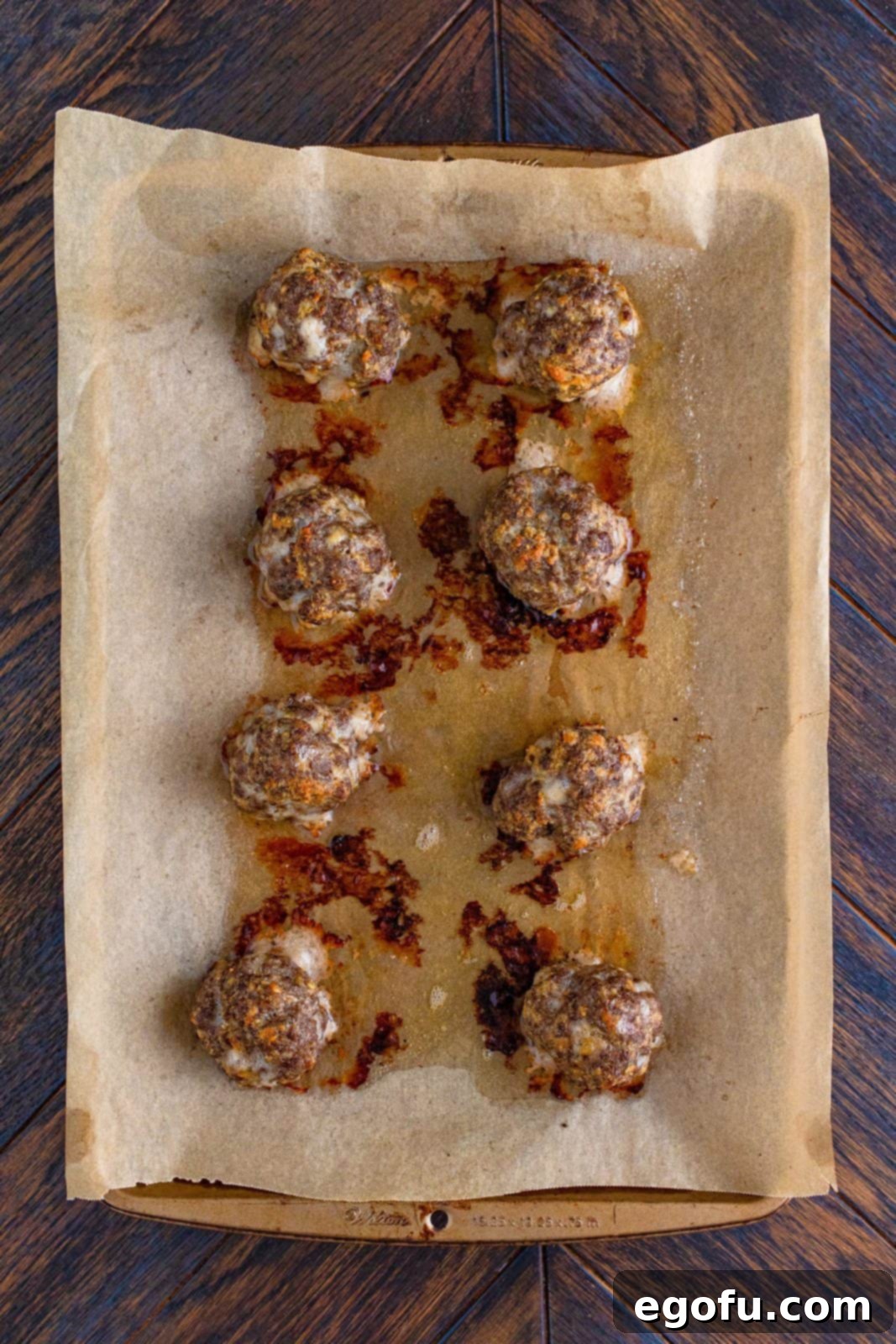 Finished meatballs out of oven on parchment lined pan.