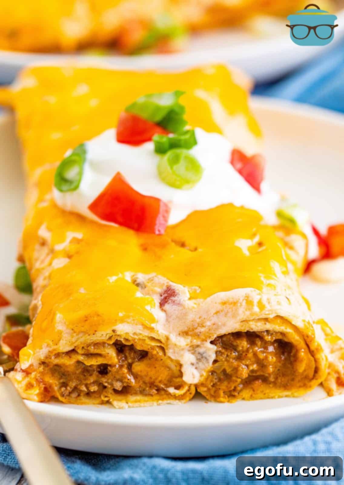 Close up of Ground Beef Enchiladas on plate showing ends and inside.