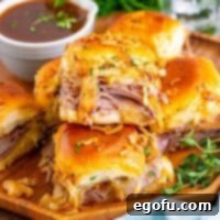Square image of stacked French Dip Sliders on wooden plate.