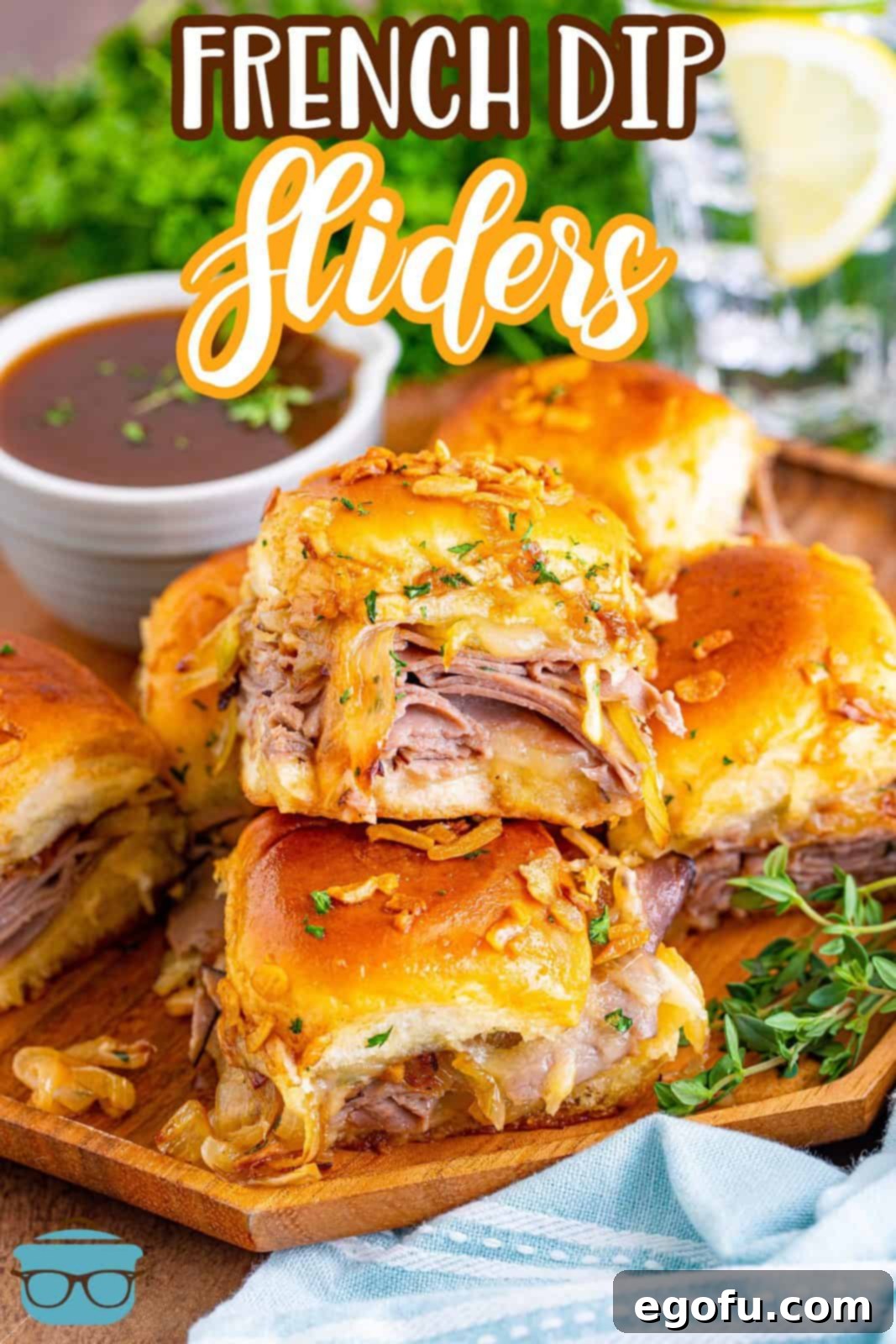 Pinterest image of French Dip Sliders stacked on top of one another on wooden plate.