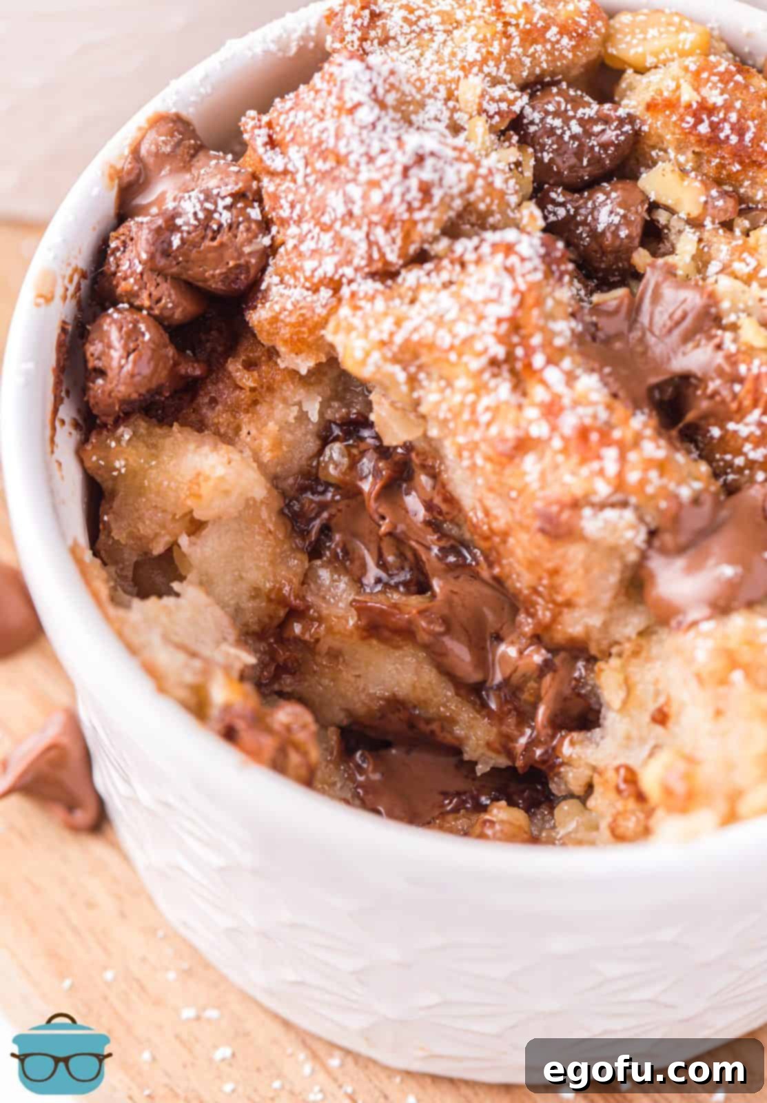 Overhead photo of one Air Fryer Bread Pudding with a scoop taken out, showcasing its rich texture and delicious filling.