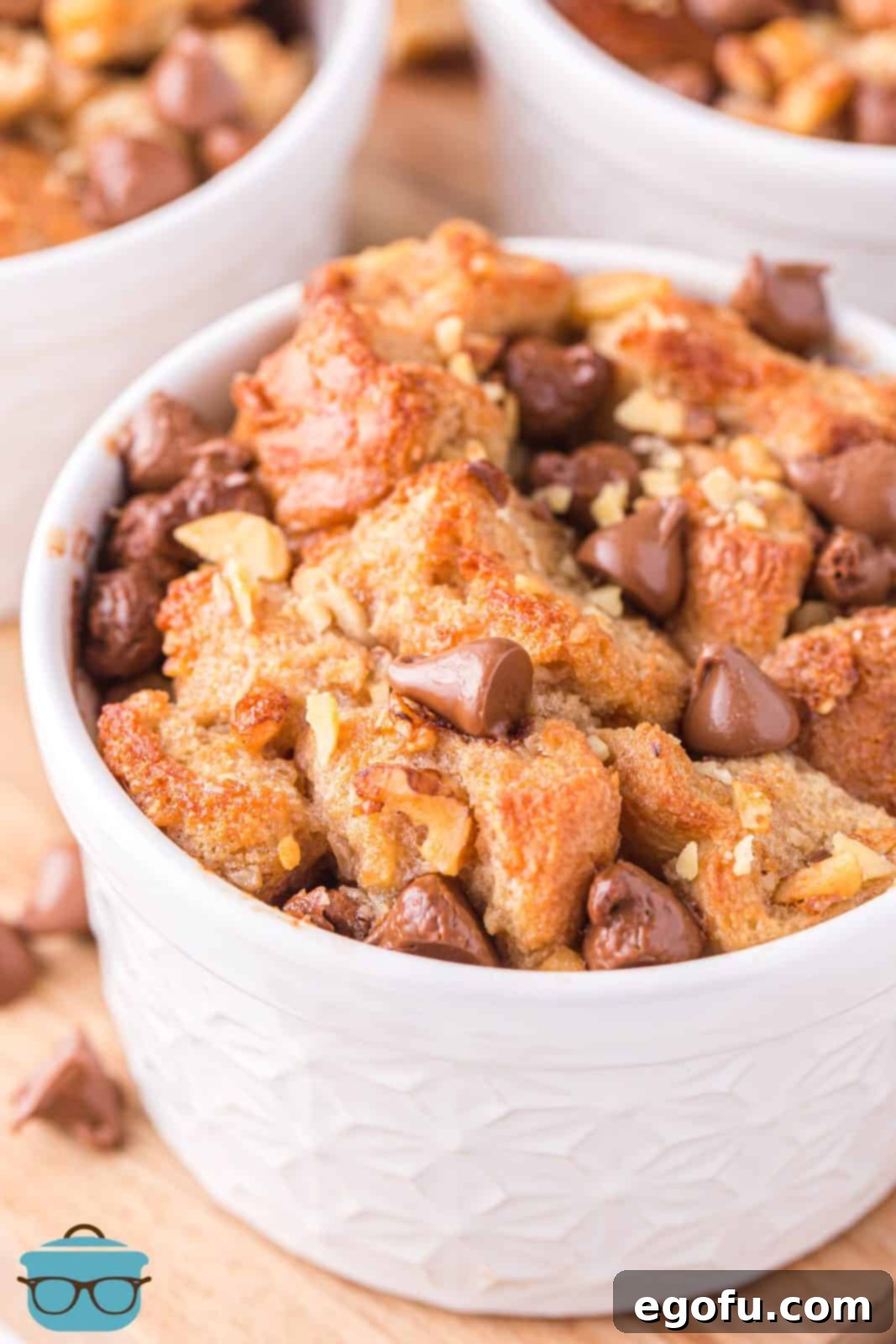A finished Air Fryer Bread Pudding, artfully plated in a white dish, clearly showing melted chocolate chips and a soft, inviting texture.