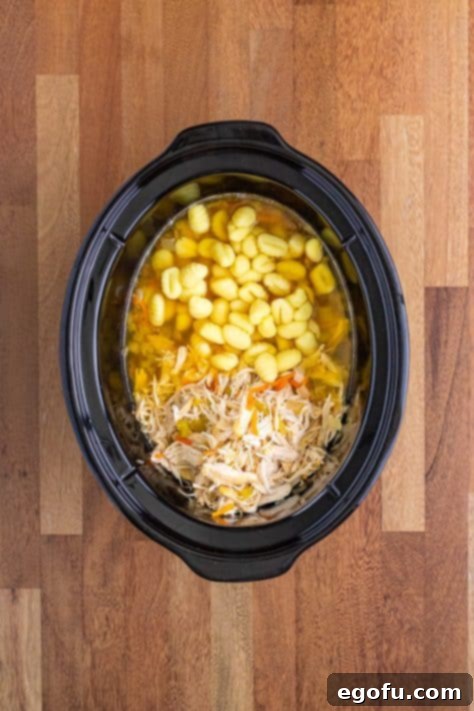 Creamy Slow Cooker Olive Garden Chicken Gnocchi Soup 12 Gnocchi and chicken added to a crockpot.