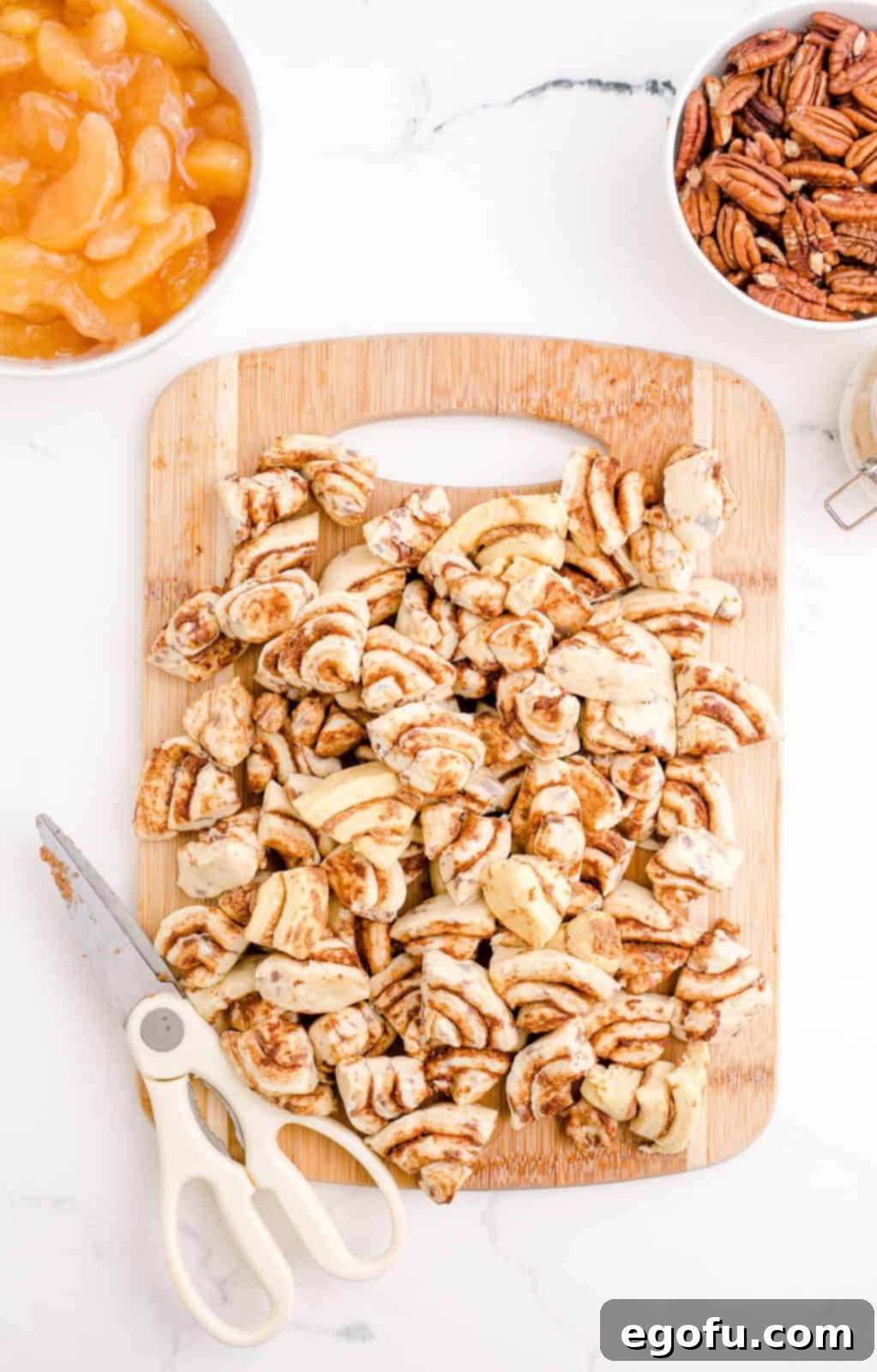 Gooey Cinnamon Roll Delight 5 Cinnamon rolls cut up on cutting board.