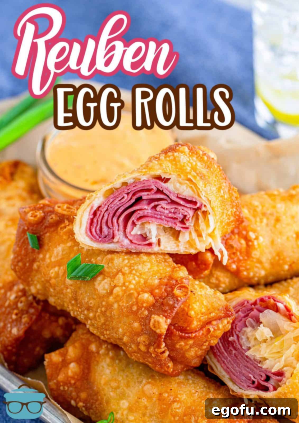 Pinterest image of stacked Reuben Egg Rolls with the top one cut in half, showcasing the delicious filling.