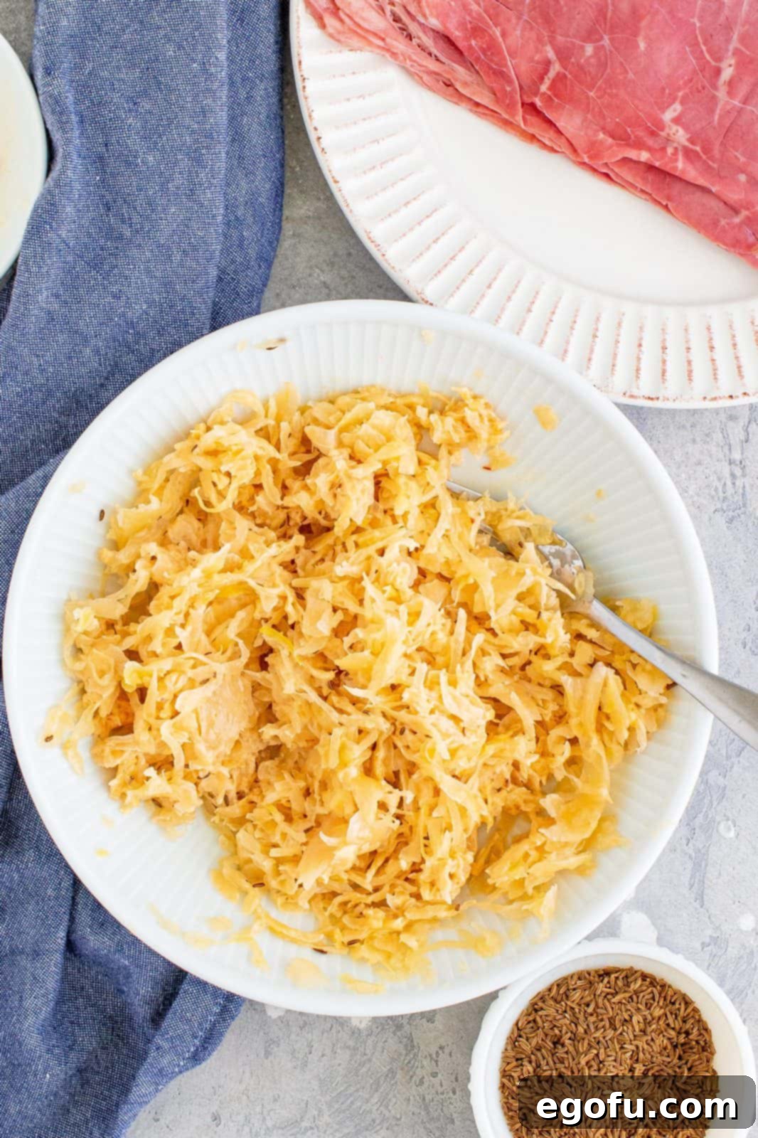 Sauerkraut mixture (sauerkraut, Thousand Island dressing, and caraway seeds) thoroughly mixed together in a bowl.