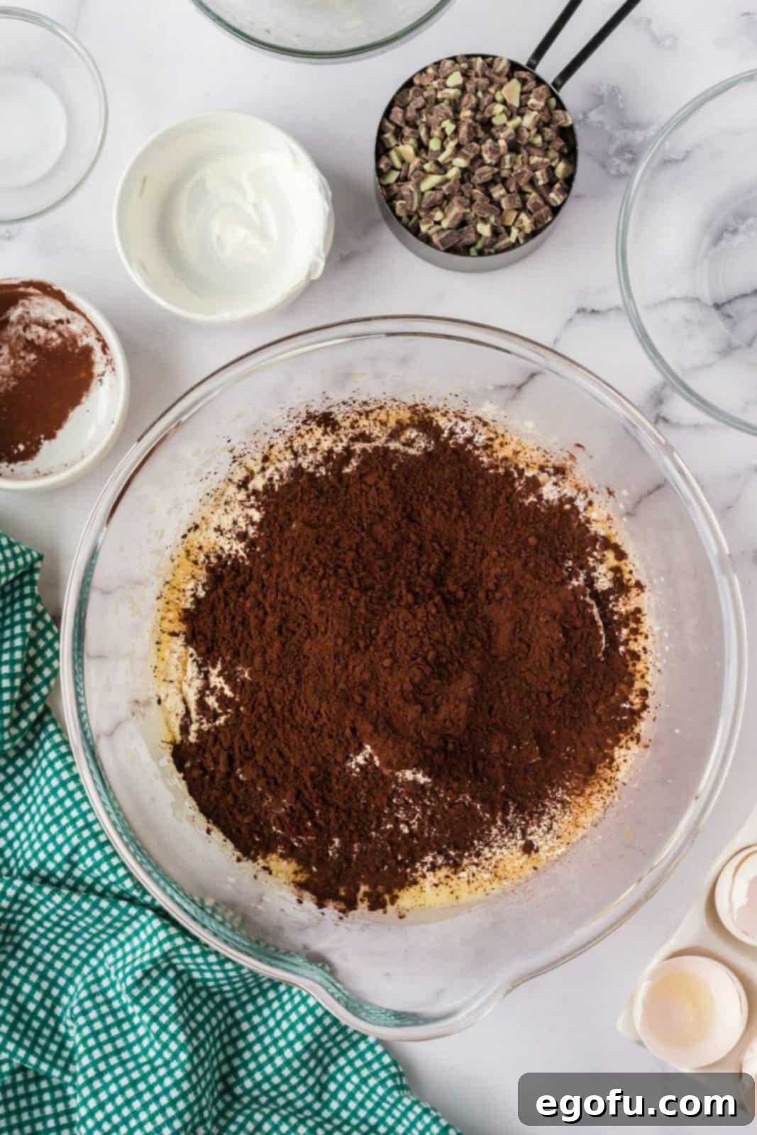 Flour, baking powder, baking soda, and cocoa powder added to egg mixture.