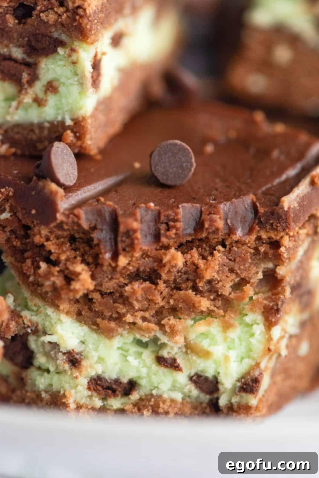 Close up of a bite taken out of one Mint Cream Cheese Brownie, revealing the layers.