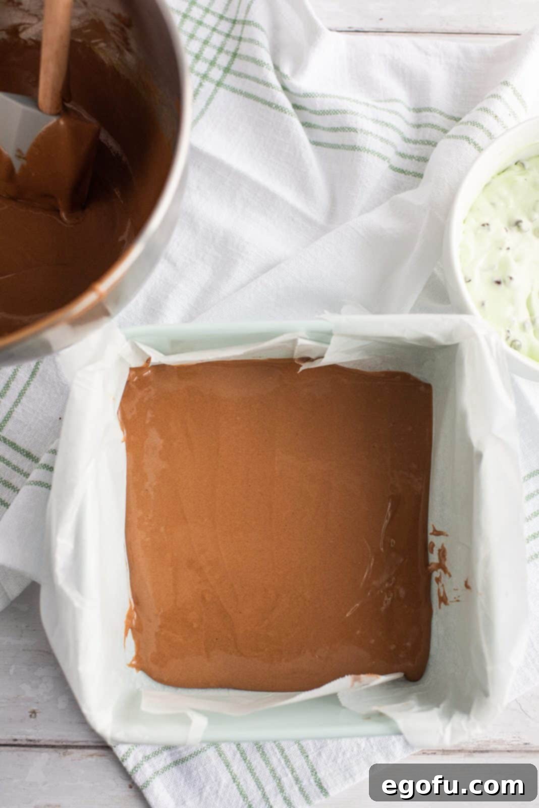 Half of the fudgy brownie batter added to the prepared baking pan.