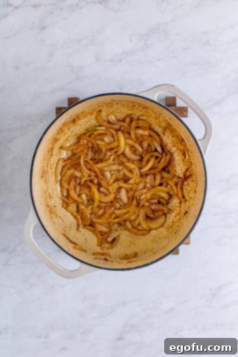 Crispy Bacon and Caramelized Cabbage 11 sliced onions cooking in a dutch oven.