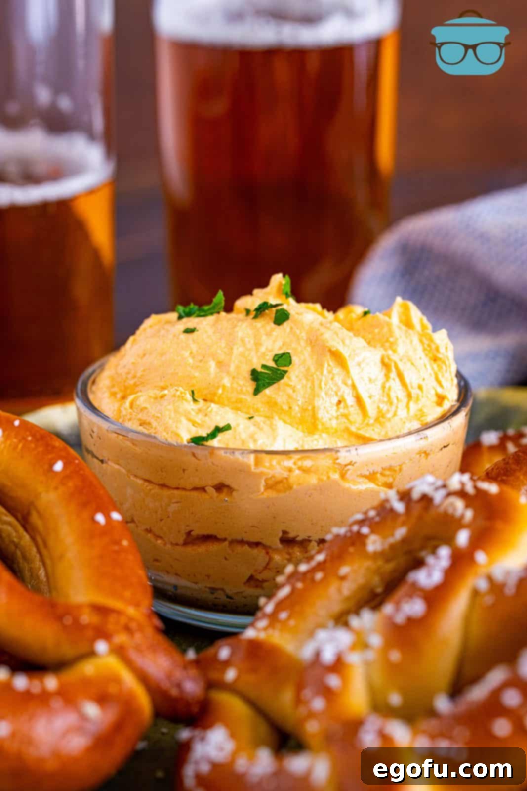 Beer Cheese Dip in bowl with pretzels and beer around it. A classic pub style cheese dip perfect for any gathering.