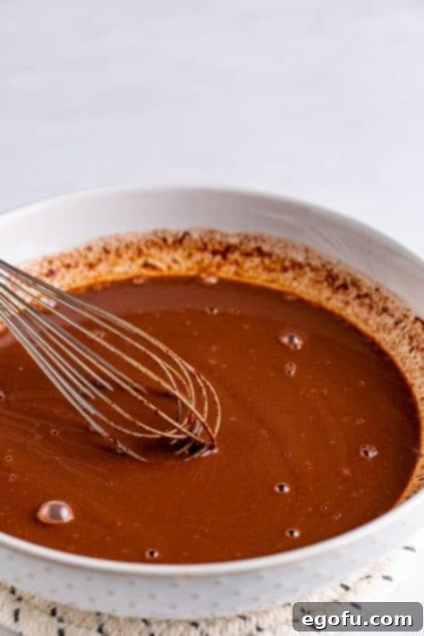 Chocolate chips and milk being whisked together in bowl.
