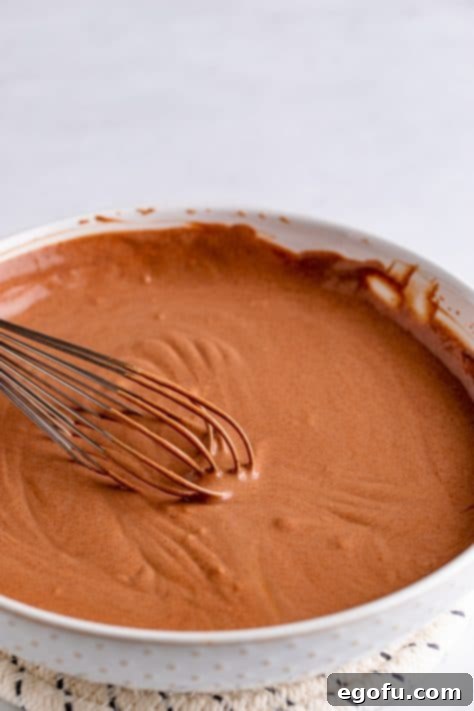 Sour cream being mixed to chocolate mixture.