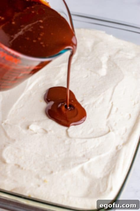 Ganache being poured over cake.