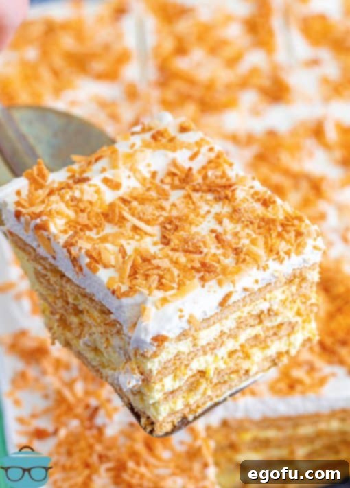 Metal spatula holding up slice of Coconut Icebox Cake.