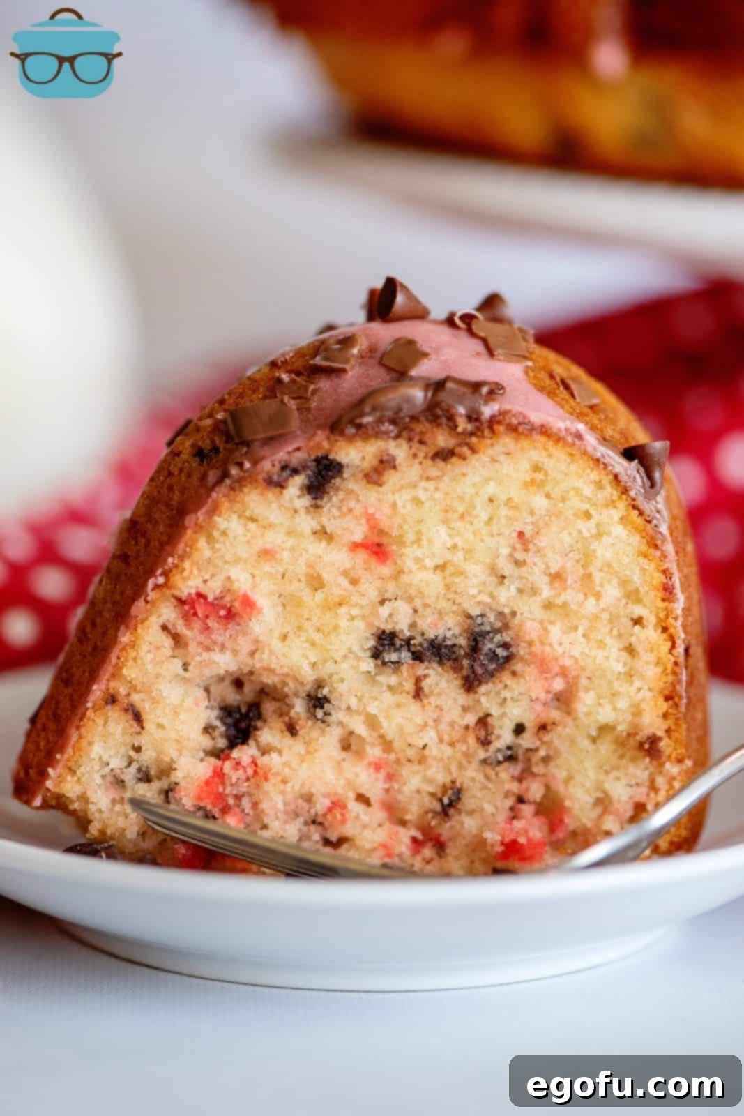 One slice of Cherry Chocolate Chip Cake on white plate.