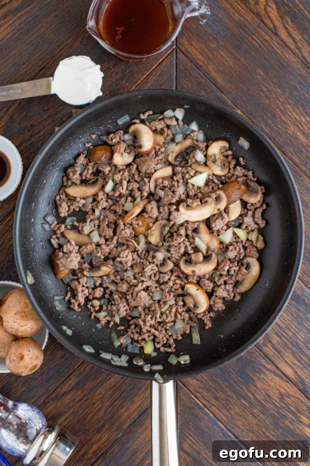 Ground beef, mushrooms, onion, and garlic sauteed in pan.