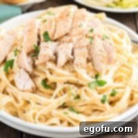 Square image close up of Copycat Olive Garden Chicken Alfredo in bowl, showing rich sauce and tender chicken.