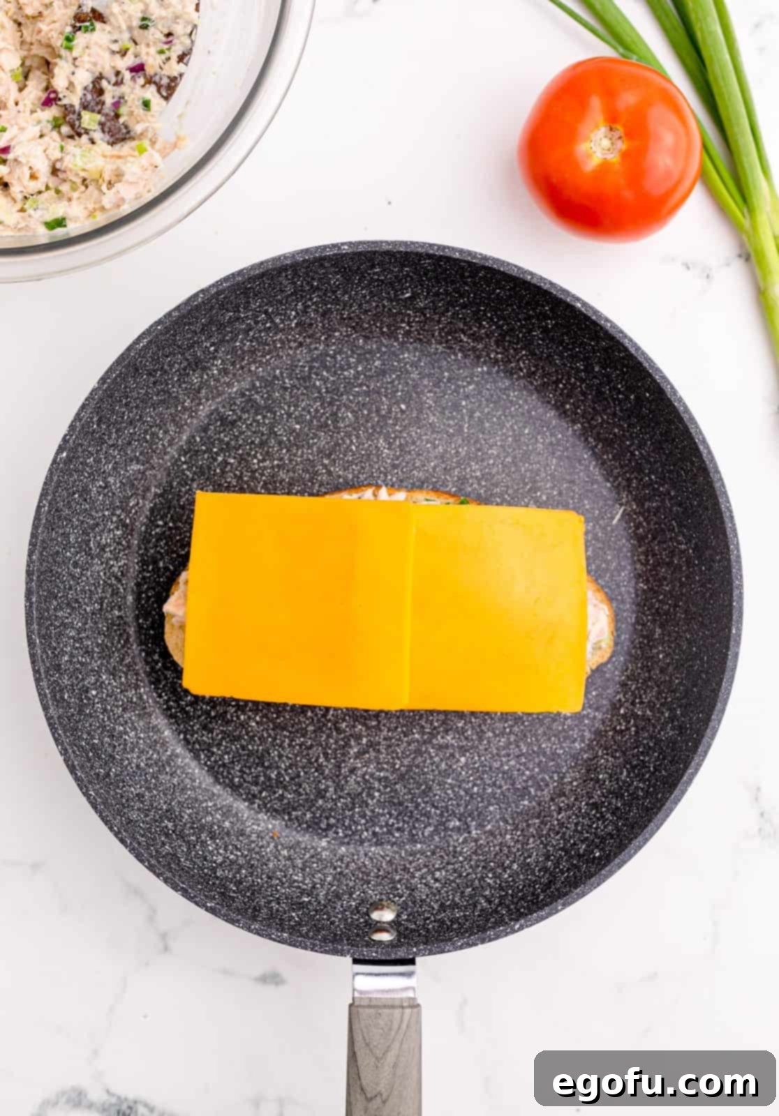 Golden Grilled Tuna Melt 8 Tomato slices and cheese placed over tuna mixture.