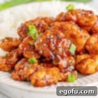 Square image of Easy Sesame Chicken on plate with rice.
