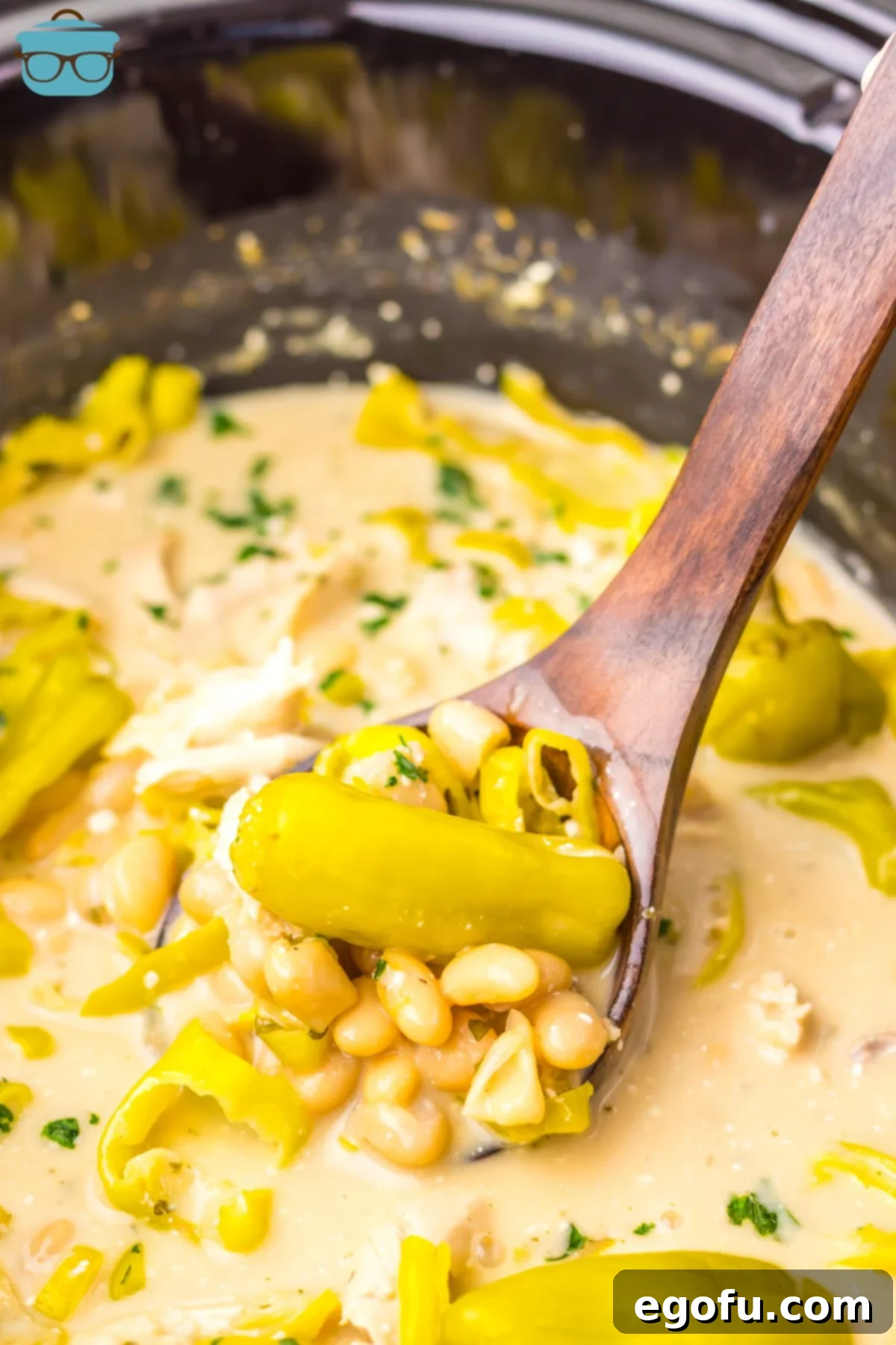 A serving spoon scoops up a generous portion of Crock Pot Mississippi White Chicken Chili.