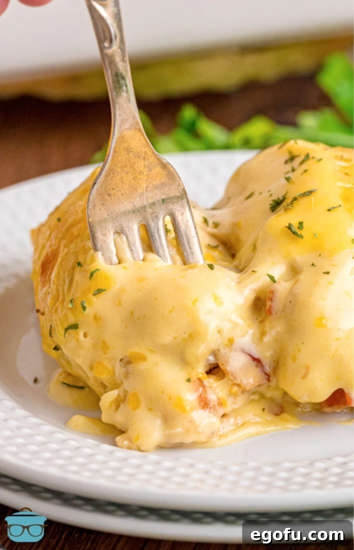 Cheesy Chicken Crescents 12 A fork getting a bite of Cheesy Chicken Crescent Roll on a plate.