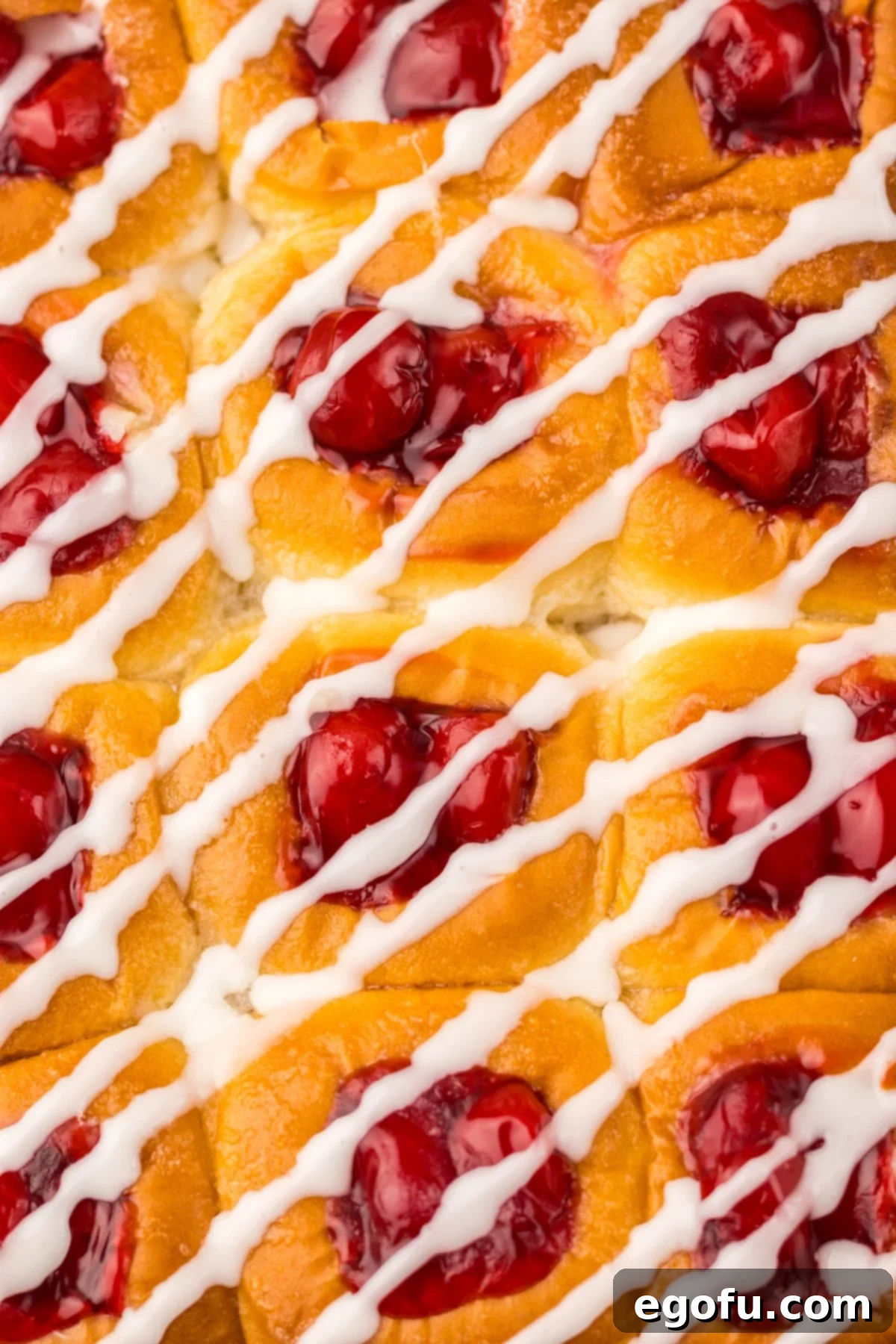 Hawaiian Sweet Roll Cherry Pastries 2 Overhead view of several iced Hawaiian Roll Cherry Danishes arranged on a baking sheet.