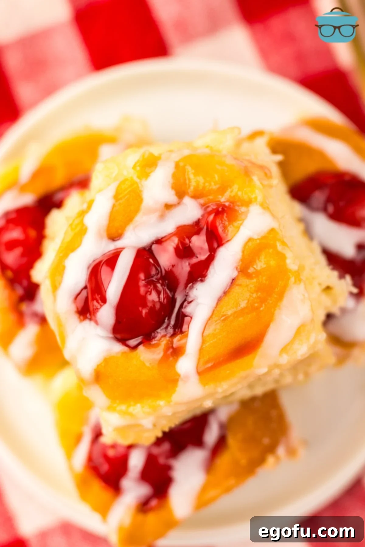 Hawaiian Sweet Roll Cherry Pastries 8 A close-up overhead shot of a single, perfectly glazed Hawaiian Roll Cherry Danish, showcasing the gooey cherry filling and the soft, sweet roll.