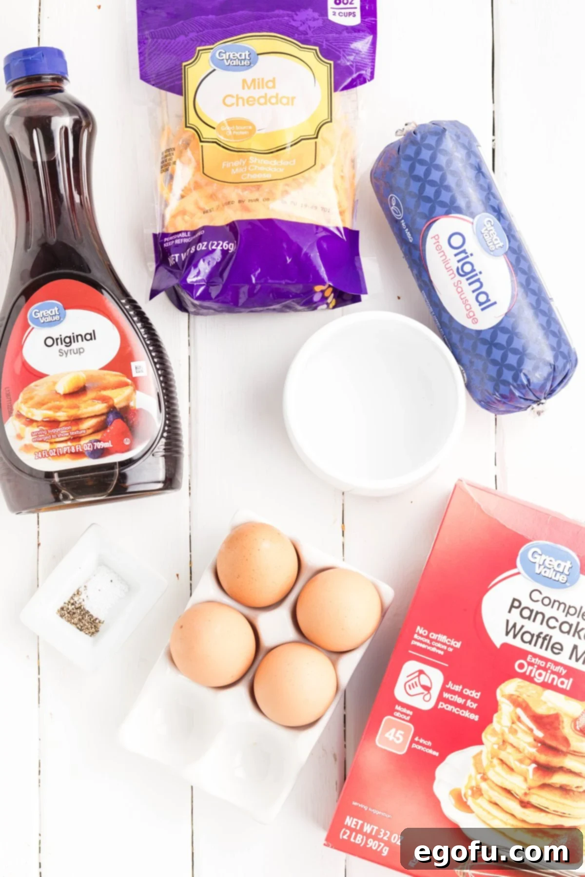 McGriddle Muffins
McMuffin Magic: Sweet & Savory Bites 4 An arrangement of the necessary ingredients for McGriddle Muffins: sausage, eggs, pancake mix, syrup, water, salt, pepper, and cheese.