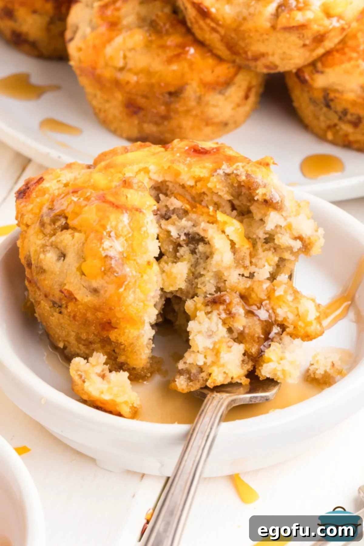 McGriddle Muffins
McMuffin Magic: Sweet & Savory Bites 9 A close-up of a McGriddle Muffin being split open with a fork, revealing its delicious interior and a generous drizzle of syrup.