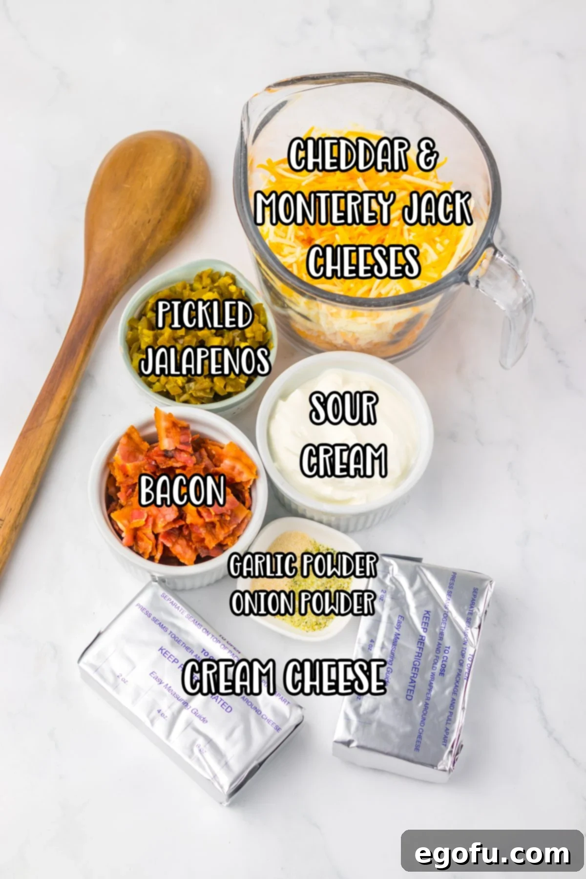 A beautiful array of ingredients including bacon, cream cheese, sour cream, shredded cheddar cheese, shredded Monterey Jack cheese, diced pickled jalapeños, jalapeño juice, garlic powder, and onion powder.