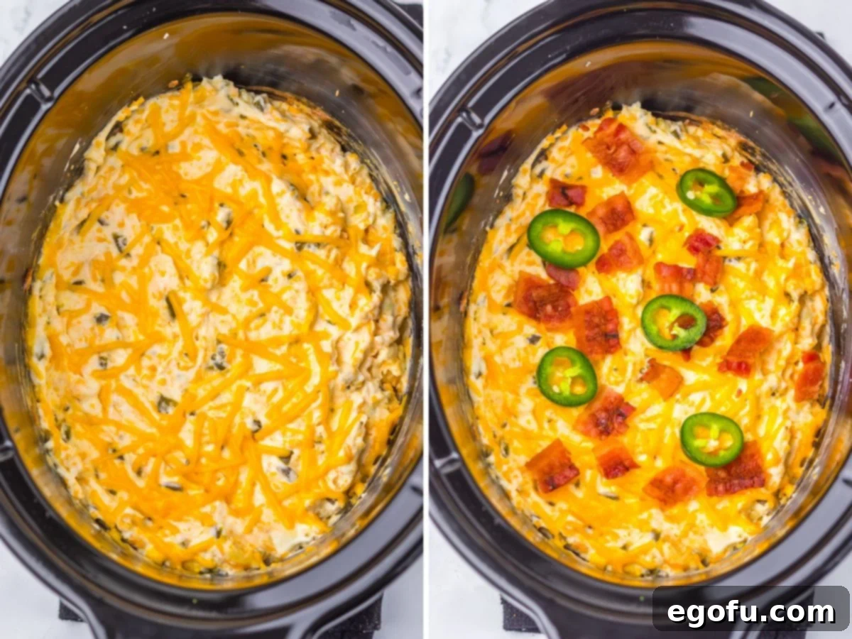 A close-up shot of Cheesy Jalapeno Popper Dip bubbling in a slow cooker, topped with bacon and fresh jalapenos.